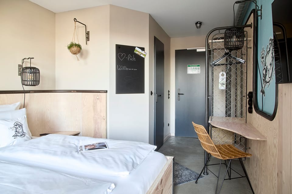 Helles Hotelzimmer der Bretterbude Büsum mit Balkon
